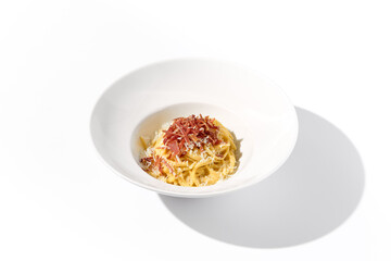Classic Italian Carbonara Pasta with Bacon, Cheese, and Egg Yolks, Served in a White Bowl for a Traditional Culinary Experience