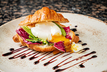 croissant with poached egg and salad