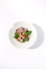 Greek salad with crisp vegetables and feta cheese isolated on white background, top view