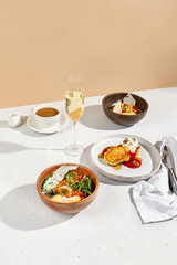 Breakfast ensemble with omelet, porridge, and pancakes, served with coffee and milk, alongside sparkling wine