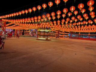 The image shows a red lantern lit up at night. The background is dark, so the lantern looks bright.