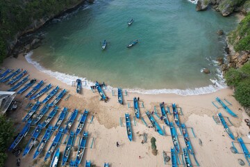 Blue fishing boats anchored on the shore. White sandy beach with blue turquoise crystal sea water. 