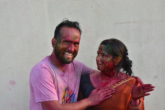 Portrait of a young Indian boy and girl playing holi. Happy couple enjoying in holi festival. Portrait of Indian couple covered in holi colors. Happy holi.