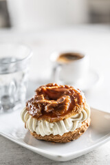 Veternik - sweet donut, typically Slovak caramel sweet cake with cream filling topped with caramel on a plate in a cafe