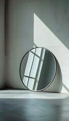a round mirror sitting on top of a white floor