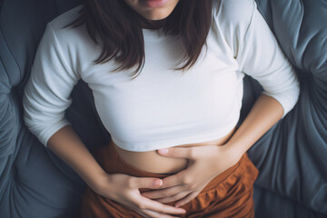 Woman with menstrual cramps clutching stomach in pain - obrazy, fototapety, plakaty