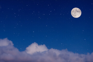 Fototapeta na wymiar ночной пейзаж. полная луна и яркие звезды на ночном небе, облака внизу. концепция астрономии и ночи