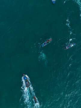 Aerial landscape of sea surface with fishing boats of Vietnamese fishermen catching fish in the morning. Tourism, fishery or maritime background. © VanQuy
