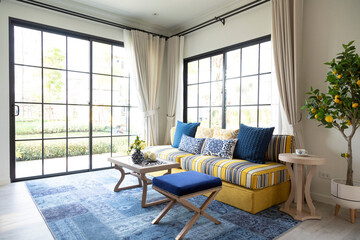 Mediterranean living room interior with bright yellow and blue sofa and pillow. Modern decor living room with carpet.