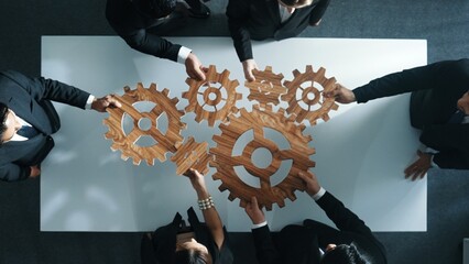 Top view of smart business people gather wooden cog together at meeting. Group of project manager...