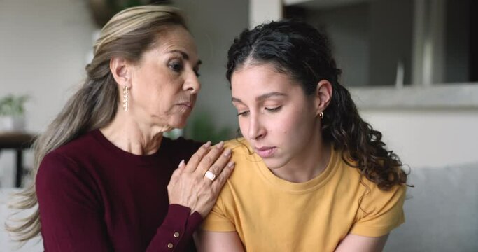 Caring empathetic older mother talking to frustrated young adult daughter, give advice, calming her, show sympathy, supporting in difficult life situation, break up, personal life concerns or divorce