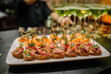 Riga, Latvia - January 18, 2024 - Canapes on a white plate with blurred background, catering at an...