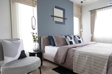 Stylish Bedroom in blue and white tone pillows setting. Cozy bedroom with art wall.
