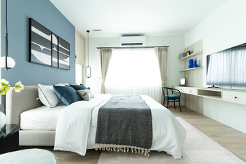 Fototapeta na wymiar Stylish Bedroom in blue and white tone pillows setting. Cozy bedroom with art wall.