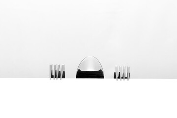 Forks and spoons are discussing at the table. Hiding behind the table, they watch what is happening on the table. 