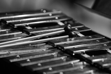 Drumsticks lying on a metallophone close-up in black and white
