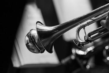 A fragment of a trumpet in the hands of a musician in black and white