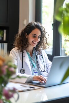 a woman doctor is sitting at his desk smiling with his laptop