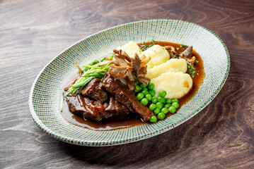Stewed beef veal cheeks with mashed potatoes on plate