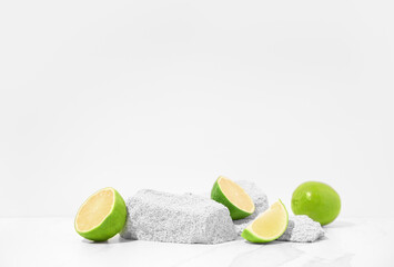 Cosmetics product presentation scene made with porous stone podium and sliced limes.