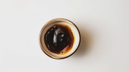 A small dish with molasses on a white background.