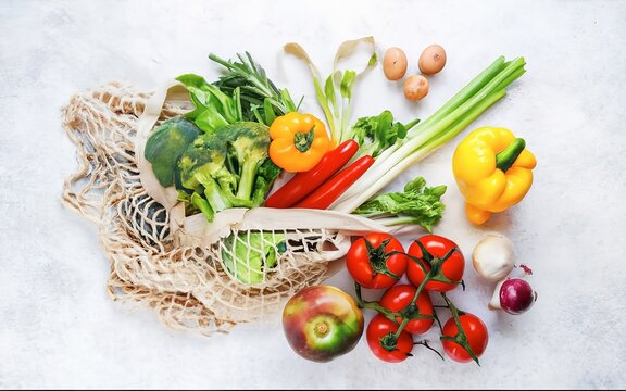 Fresh vegetables in a bag on a white table. Top view, flat lay