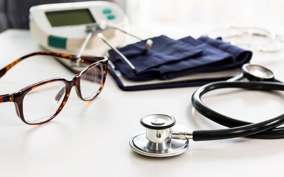 Glasses, stethoscope, pressure gauge on a white table