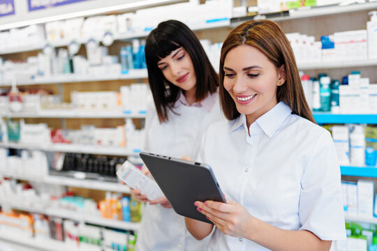 Two beautiful pharmacists working together in a drug store and doing a stock take. Portrait of a positive healthcare workers or a chemists at their work.