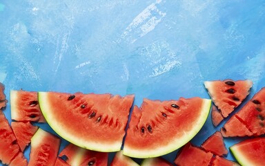 Slices of juicy red watermelon on blue. Top view, flat lay