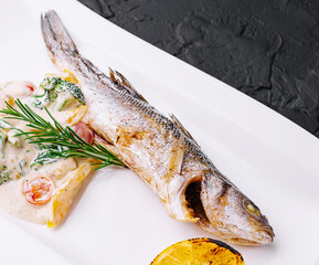 fish with broccoli and sauce on a white plate