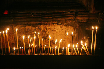 Pilgrims burning a candle close at the place where Jesus Christ was crucified in the Church of the...