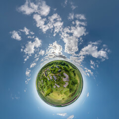 tiny planet in sky with clouds overlooking village with river. Transformation of spherical 360 panorama in abstract aerial view.