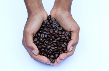 Holding some Roasted coffee beans in a hand top view 