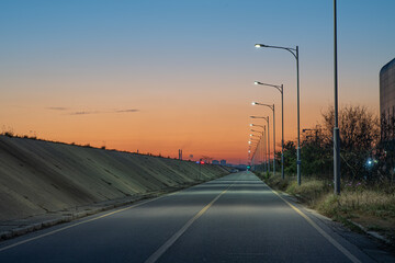 A quiet road without cars with a view of the sunrise
