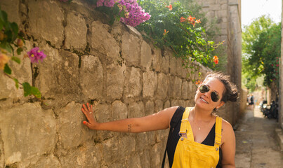 woman with sunglasses and a yellow dress smiling in the summer hollidays