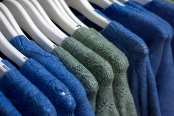 closeup of colorful woolen pullover on hangers in a woman fashion store showroom - 733023481