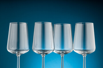 Elegant wine glasses in beautiful light with blue background