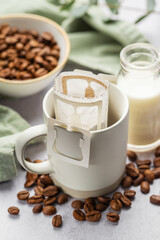 Drip coffee bag with ground coffee in  cup