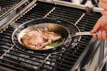 A steaming beef tenderloin steak is grilled in a grill pan. The concept of the recipe, T-bone...