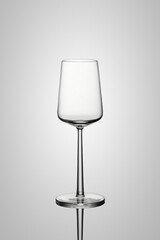 A wine glass in beautiful light with reflection and light gray background