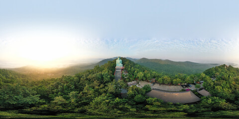 Fototapeta premium Aerial view of The Great Buddha at Doi Phra Chan is a towering bronze Buddha statue that can be reached by climbing 628 steps up at wat Prathat Doi Prachan, Pa Tan, Mae Tha District, Lampang, Thailand