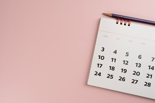 close up of calendar and pencil on the pink table background, planning for business meeting or travel planning concept