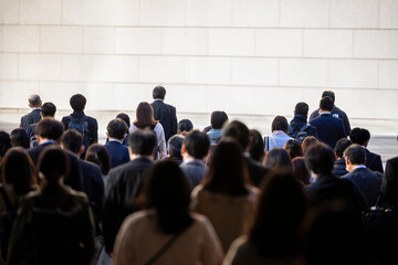 朝の通勤するビジネスマンたちの後ろ姿　東京