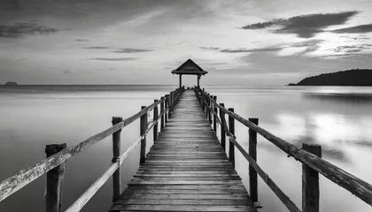 Fototapeten old wooden bridge or pier to the sea in black and white thailand © Debbie