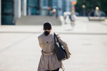 若いスーツ姿の日本人女性の歩く後ろ姿