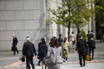 若いスーツ姿の日本人女性の歩く後ろ姿