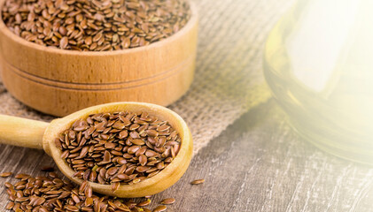 Brown flax seeds and flaxseed oil on the wooden table on sunlight