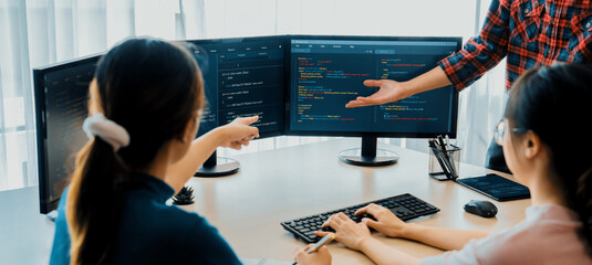 Young Professional website developer and cooperative computer engineer team brainstorming and sharing idea of program writing and coding at modern meeting room. Teamwork concept. Closeup. Burgeoning.