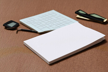 Blank business cards with calculator and pen on the wooden table.