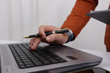 Close up of male hand working with business and forex chart of downward trend and financial downfall concept.